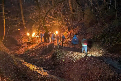 Kollegiaten bei einer Fackelwanderung aus der Entfernung zu sehen
