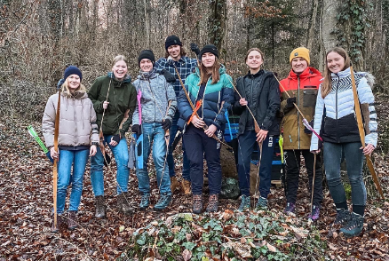 Mehrere junge Erwachsene stehen nebeneinander im Wald, ein Gruppenfoto