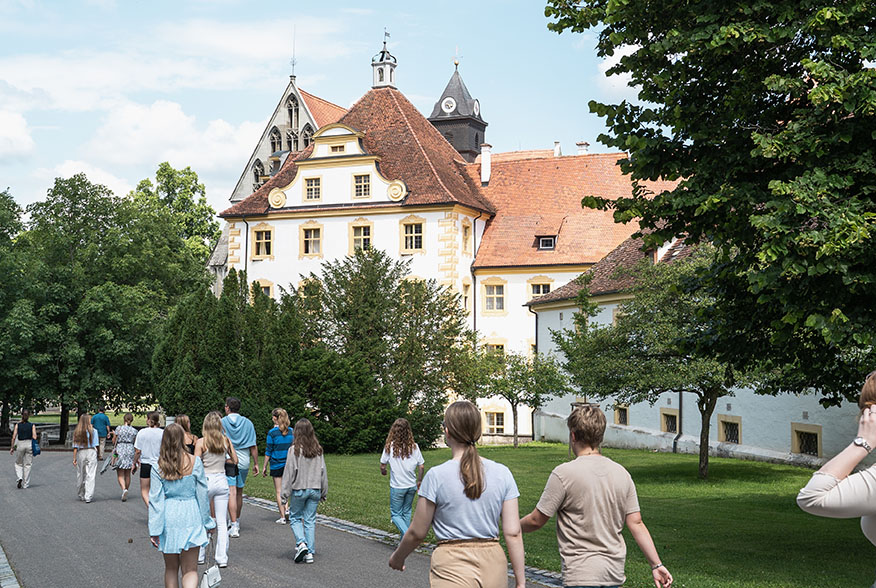 Kollegiaten laufen auf das Münster und Konventsgebäude zu